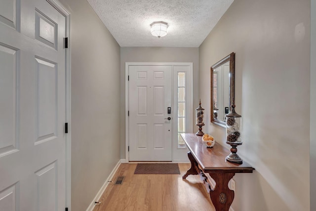 entrance foyer featuring a textured ceiling and light hardwood / wood-style floors