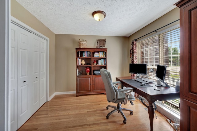 office area with a textured ceiling and light wood-type flooring