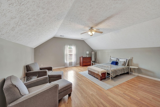 bedroom featuring lofted ceiling, wood-type flooring, a textured ceiling, and ceiling fan