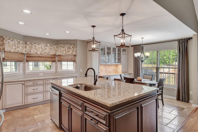 kitchen featuring sink, dishwasher, pendant lighting, and an island with sink