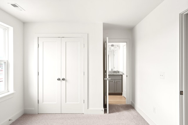 unfurnished bedroom with light colored carpet