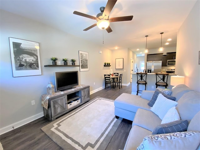 living room featuring ceiling fan and dark hardwood / wood-style flooring