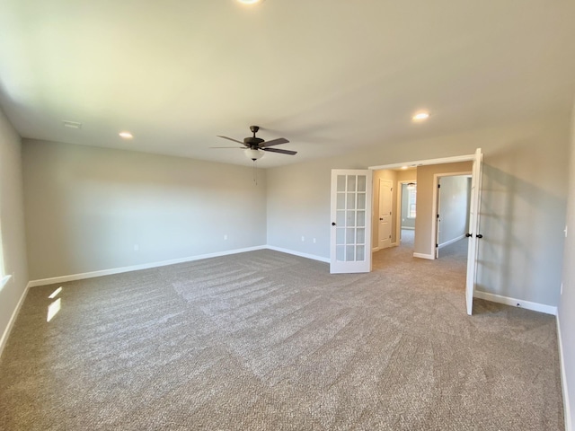 carpeted spare room featuring french doors and ceiling fan