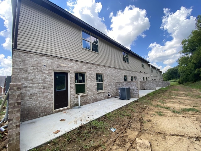 back of property with central AC and a patio area