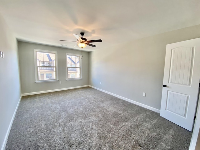 unfurnished room featuring ceiling fan and dark carpet