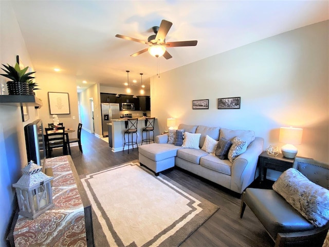 living room featuring dark wood-type flooring and ceiling fan