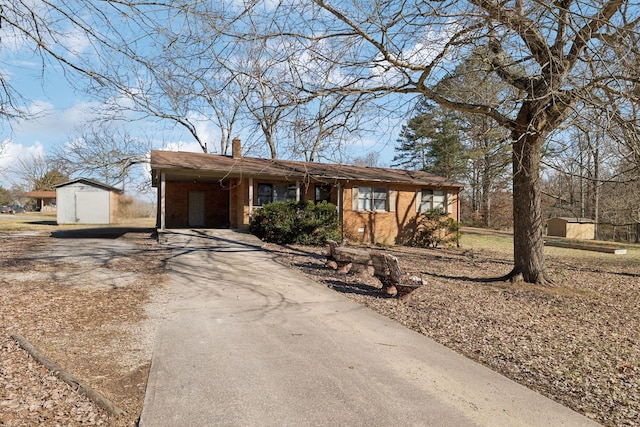 single story home featuring a garage, an outdoor structure, and a carport