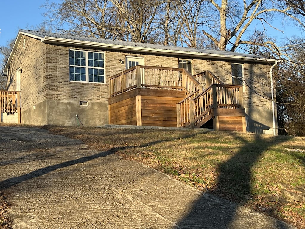 view of front facade with a front yard and a wooden deck