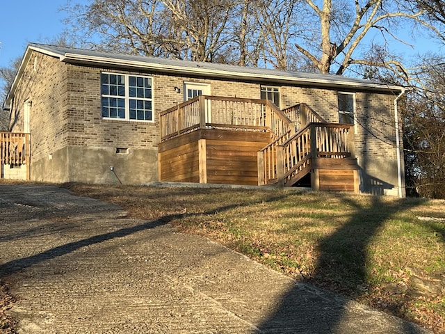 view of front facade with a front yard and a wooden deck