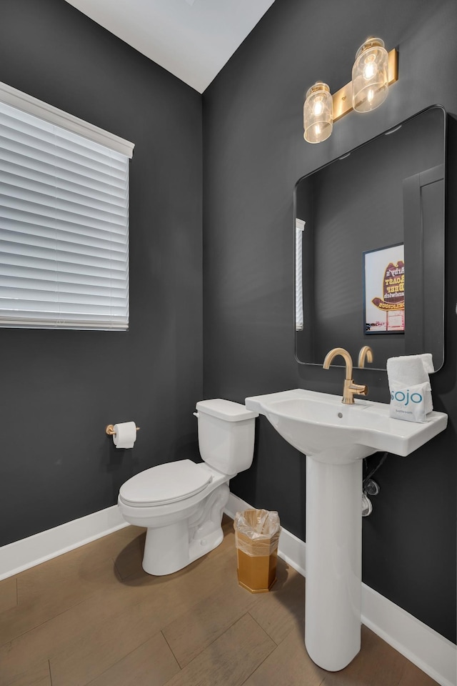 bathroom featuring wood-type flooring and toilet