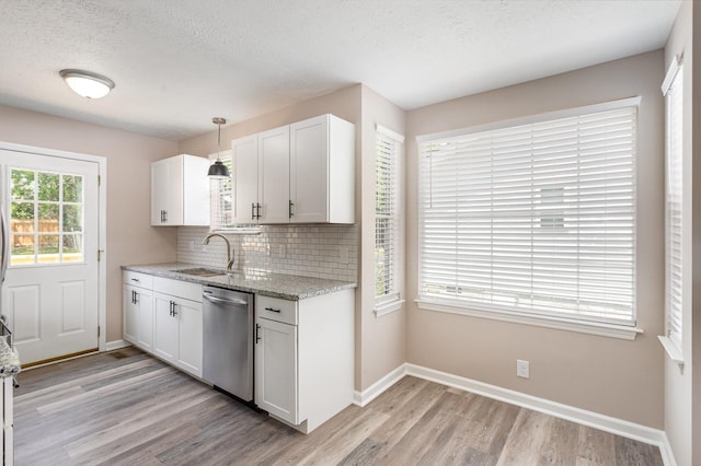 kitchen with white cabinets, dishwasher, sink, decorative light fixtures, and tasteful backsplash