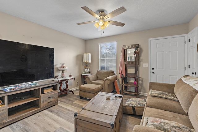 living room featuring a textured ceiling, ceiling fan, and light hardwood / wood-style floors