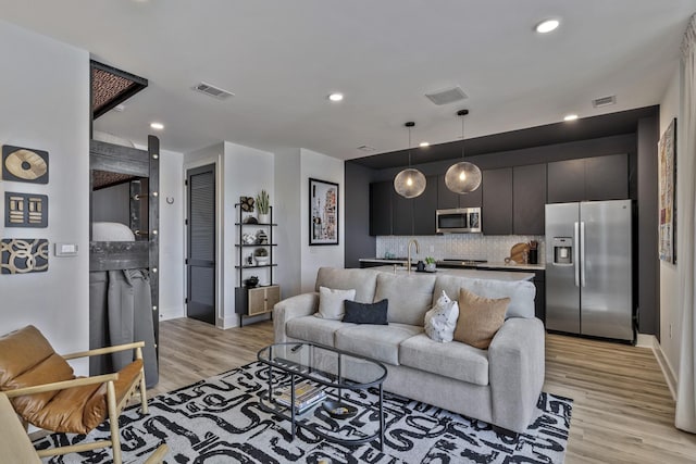 living room featuring sink and light wood-type flooring