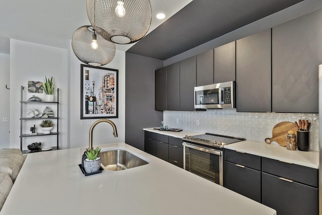 kitchen featuring appliances with stainless steel finishes, hanging light fixtures, decorative backsplash, and sink