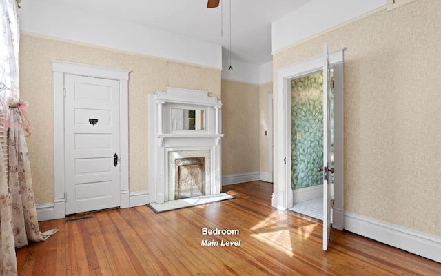 unfurnished living room with ceiling fan and hardwood / wood-style floors