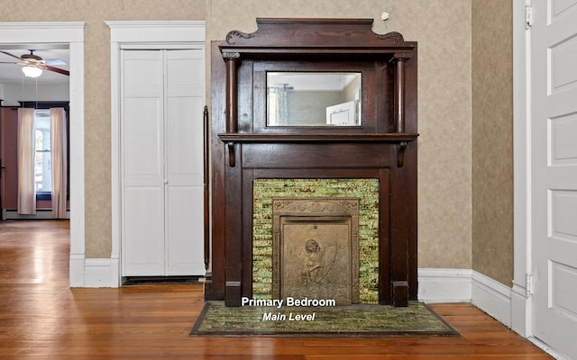 interior details with ceiling fan, baseboard heating, and hardwood / wood-style floors