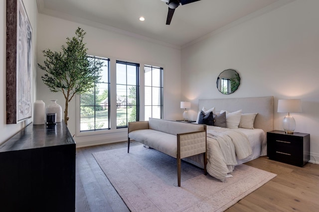 bedroom featuring ceiling fan, light hardwood / wood-style floors, and ornamental molding