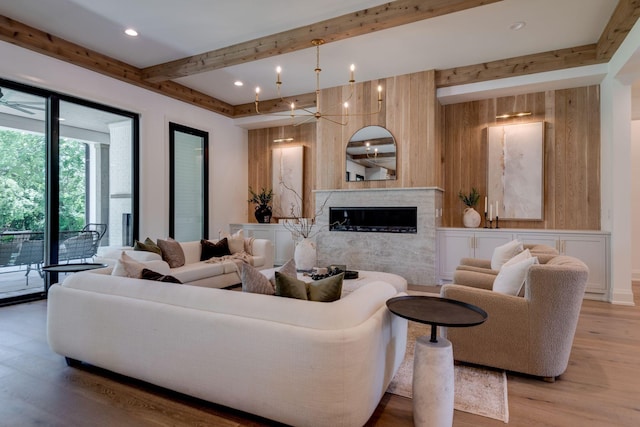 living room with a premium fireplace, a chandelier, and hardwood / wood-style flooring