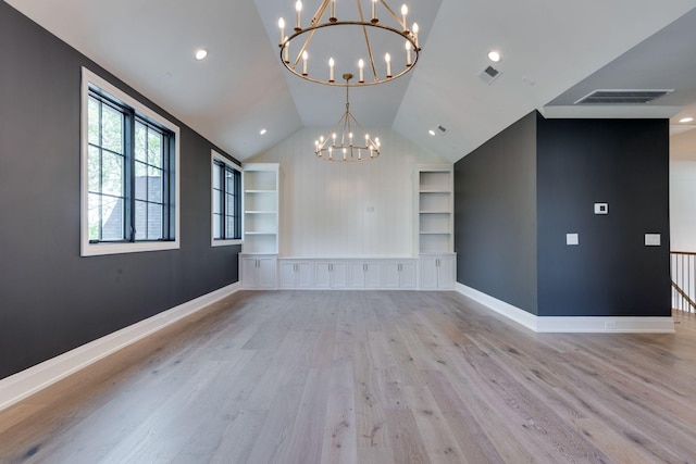 interior space with lofted ceiling, built in features, light hardwood / wood-style flooring, and a chandelier