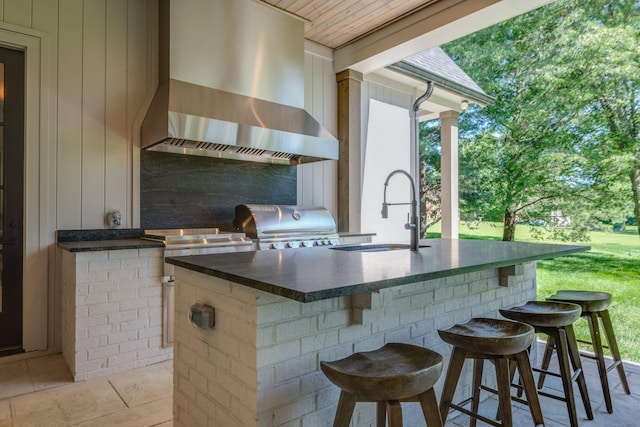 view of patio featuring an outdoor wet bar, an outdoor kitchen, and area for grilling