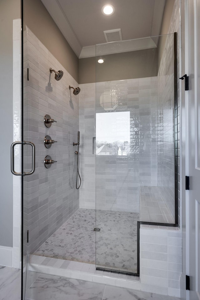 bathroom with ornamental molding and an enclosed shower