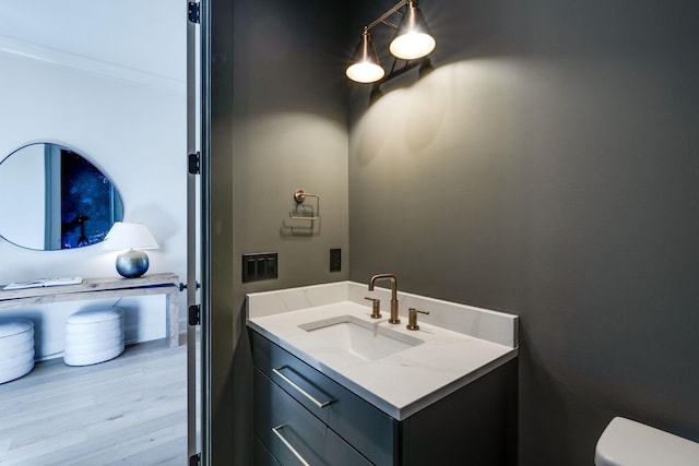 bathroom with toilet, wood-type flooring, and vanity