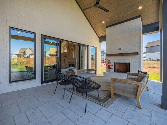 view of patio / terrace featuring ceiling fan and an outdoor living space with a fireplace