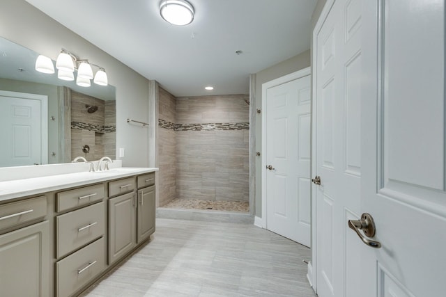 bathroom featuring a tile shower and vanity