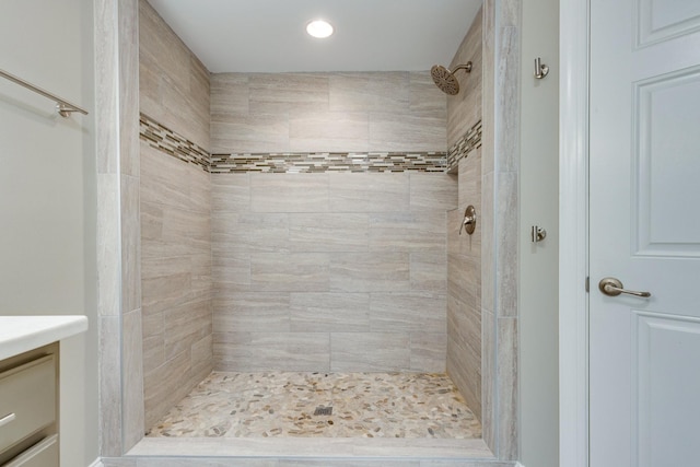 bathroom featuring tiled shower and vanity