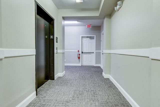 hall with elevator and carpet