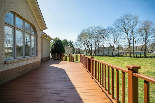 wooden terrace featuring a yard