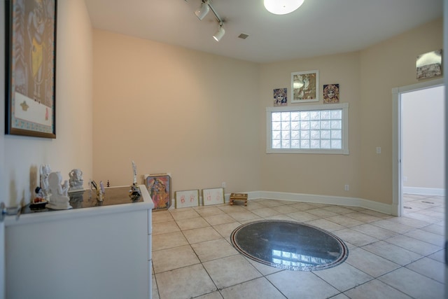 interior space featuring track lighting and light tile patterned floors