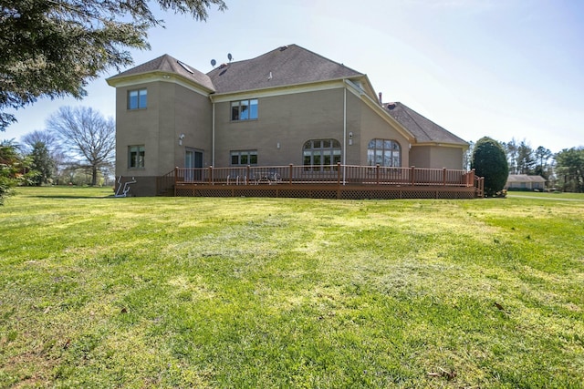 back of property with a yard and a wooden deck