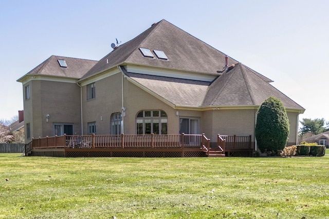 rear view of house with a deck and a yard