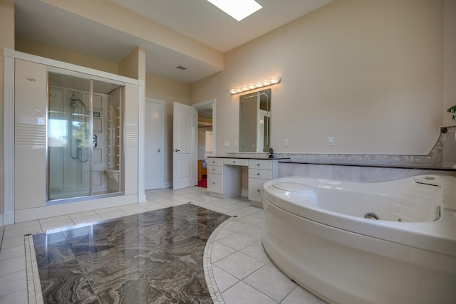 bathroom with independent shower and bath, a skylight, tile patterned floors, and vanity