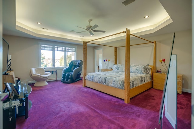 carpeted bedroom featuring a raised ceiling and ceiling fan