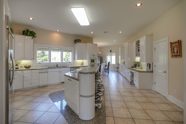 kitchen featuring a breakfast bar area, white cabinetry, and a center island