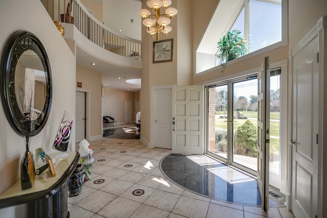 tiled foyer entrance with a high ceiling and a chandelier