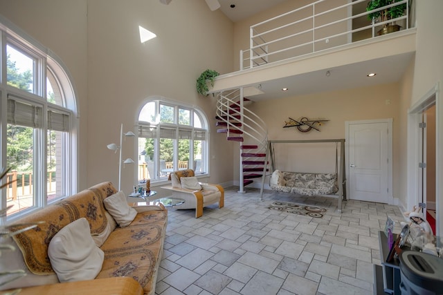 living room with ceiling fan and a towering ceiling