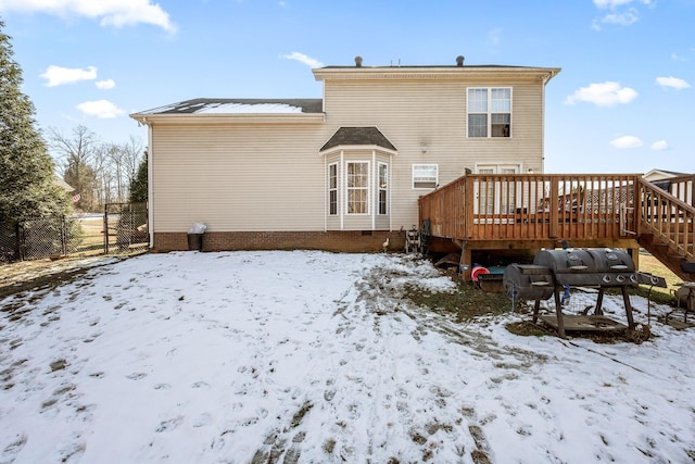 snow covered house with a wooden deck