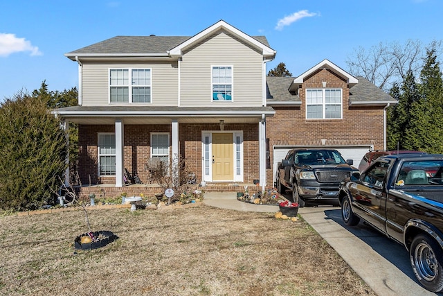 view of front of property with a front yard, a garage, and covered porch