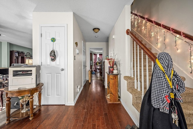 hallway featuring a textured ceiling and dark hardwood / wood-style floors