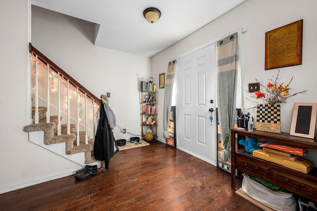 entrance foyer with a textured ceiling and dark hardwood / wood-style floors