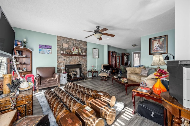 living room with a textured ceiling, a fireplace, and hardwood / wood-style flooring