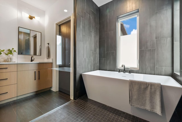 bathroom featuring vanity, tile patterned floors, plenty of natural light, and a bathing tub