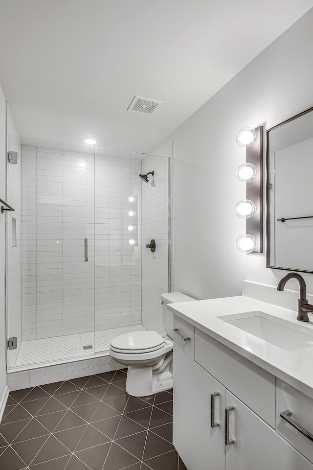 bathroom with toilet, tile patterned flooring, walk in shower, and vanity