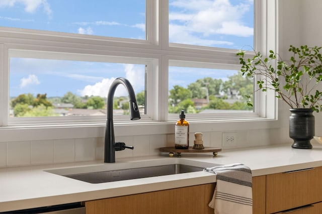 details with sink, stainless steel dishwasher, and decorative backsplash