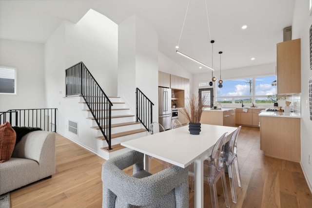 dining space featuring light hardwood / wood-style floors and vaulted ceiling