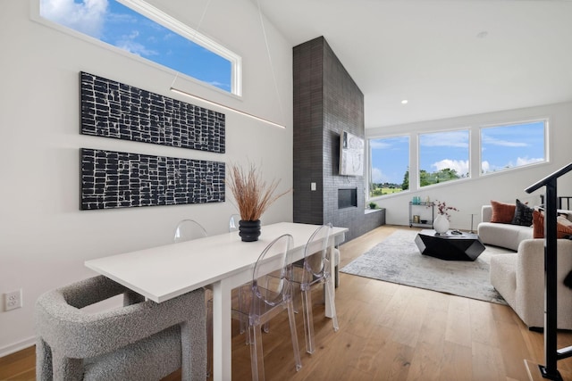 dining area with a large fireplace and hardwood / wood-style floors