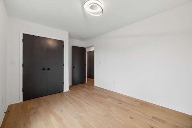 unfurnished bedroom with light hardwood / wood-style floors and a closet